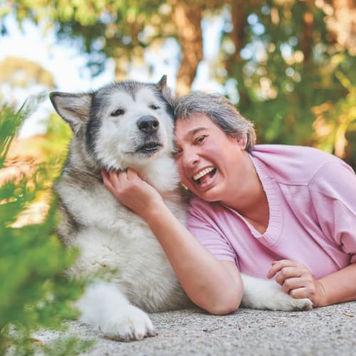 smiling woman with Malamute dog