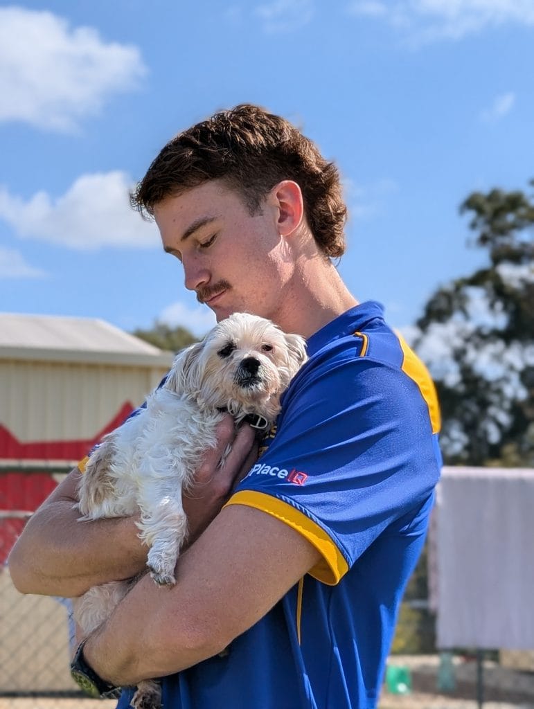 Ambassador Archer Reid holding small dog Mochi